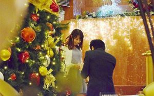 横浜ベイシェラトンホテルのメザニンロビーに設置された巨大クリスマスツリーの下でプロポーズするカップル