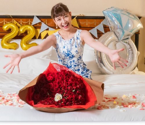 バルーンやガーランド、バラの花束と花びらでベッドを飾りつけたホテルプロポーズ演出プランのイメージ